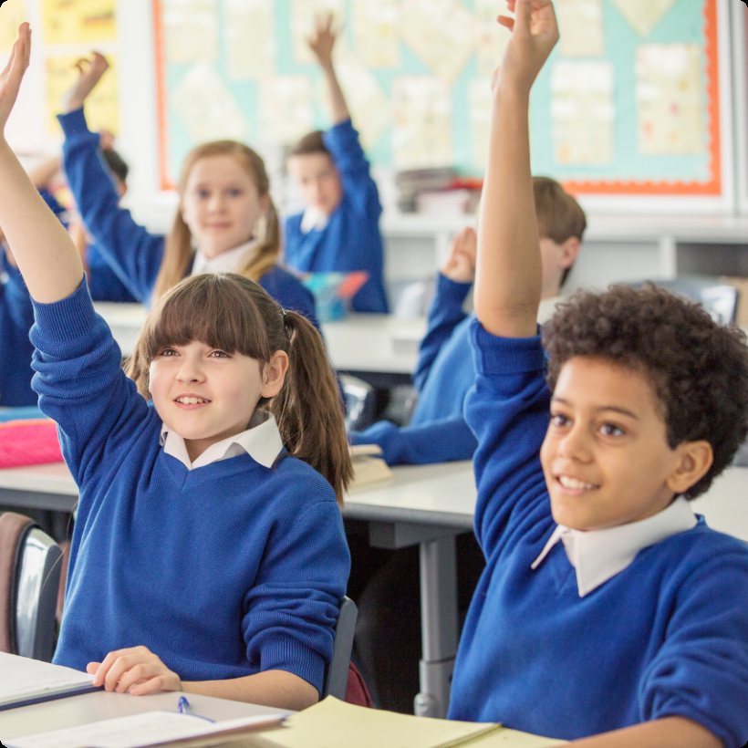 Pupils raising their hands in a classroom